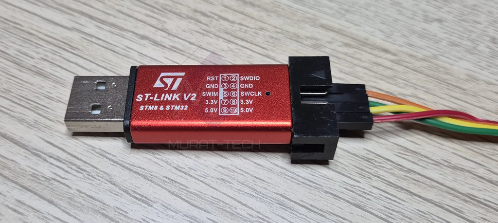 Generic USB-stick ST-Link V2 clone with an aluminum dongle case.